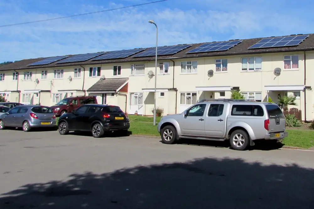 Hilera de casas adosadas con placas solares en el tejado bajo un cielo azul